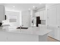Bright kitchen with stainless steel appliances, white cabinets, and quartz countertops at 716 Daring Dr, Davenport, FL 33837