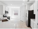 Modern kitchen featuring stainless steel appliances, white cabinets, and a quartz countertop at 716 Daring Dr, Davenport, FL 33837