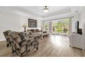 Bright living room with wood floors and sliding glass doors leading to an outdoor patio at 7613 Cabana Ct # 102, Reunion, FL 34747