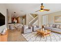 Inviting living room with neutral tones, fan, tile floors, stairs, and comfortable seating at 8430 Leatherleaf Ln, Orlando, FL 32827