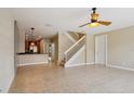 Spacious living room featuring neutral tones, tile floors, and staircase at 8430 Leatherleaf Ln, Orlando, FL 32827