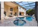 Backyard oasis featuring a screened-in pool, spa, and covered patio with outdoor seating at 9062 Dancy Tree Ct, Orlando, FL 32836