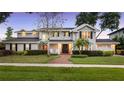 Beautiful two-story home with manicured lawn, a brick walkway, black shutters, and a two-car garage at 9146 Bay Point Dr, Orlando, FL 32819