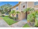 Exterior view of condo featuring well-maintained landscaping, with mature palm trees, and inviting entrance at 9900 Sweepstakes Ln # 1, Orlando, FL 32837