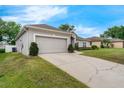 Spacious two-car garage with a concrete driveway and well-kept lawn, perfect for easy parking at 3956 Shadowind Way, Gotha, FL 34734