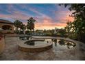 Beautiful pool and hot tub area with travertine pavers, lounge chairs, lake views and palms at 11103 Bridge House Rd, Windermere, FL 34786