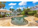 Inviting pool area with lounge chairs, umbrellas, and a serene water view at 11103 Bridge House Rd, Windermere, FL 34786