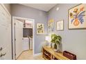 Bright hallway featuring art, a bench with storage, and a laundry room with modern washer and dryer units at 114 Vista Verdi Cir # 116, Lake Mary, FL 32746