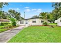 Single-story home boasting a well-manicured lawn, palm trees, and a walkway to the front door at 1170 E Bay St, Winter Garden, FL 34787