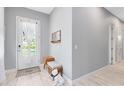 Bright foyer featuring light wood floors, gray walls, and a stylish bench with decor accents at 13334 Beebe Aly, Orlando, FL 32827