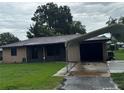 Charming single-story home featuring carport, lush lawn, and inviting curb appeal at 1335 Cr 442, Lake Panasoffkee, FL 33538