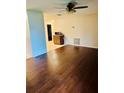 Bright living room featuring hardwood floors, a ceiling fan, and a kitchen bar for convenient entertaining at 1335 Cr 442, Lake Panasoffkee, FL 33538