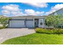 Charming home showcasing a three-car garage, paved driveway, and well-manicured lawn at 13461 Panama Beach Ct, Orlando, FL 32827