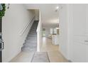 Bright entryway featuring neutral tile flooring, staircase, and an open view to the living spaces at 1462 Brookdale Ct, Oviedo, FL 32765