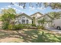 Attractive single-story home with landscaped front yard, complemented by a well-maintained lawn at 16103 Denham Ct, Clermont, FL 34711
