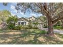Inviting single-story home with lush landscaping, a well-maintained lawn and mature trees at 16103 Denham Ct, Clermont, FL 34711