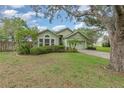 Single-story home with a two-car garage and lush landscaping on a well-maintained lawn at 16103 Denham Ct, Clermont, FL 34711