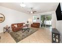 Living room featuring neutral paint, tile floor, ceiling fan, and sliding glass door to screened patio at 178 Windflower Way, Oviedo, FL 32765