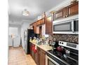 Modern kitchen featuring stainless steel appliances, dark cabinets, and tile backsplash at 1877 Attucks Ave, Orlando, FL 32811