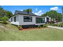 Renovated home featuring new windows, black and white exterior paint, and professional landscaping at 209 N 14Th St, Leesburg, FL 34748