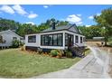 Newly renovated bungalow showcasing manicured lawn, black and white exterior, and stained staircase at 209 N 14Th St, Leesburg, FL 34748