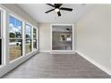 Bright living room with wood-look tile floors, large windows, and ceiling fan at 209 N 14Th St, Leesburg, FL 34748