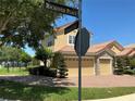 Street view of a two-story home boasting a three-car garage, red-tiled roof and manicured yard at 2258 Rickover Pl, Winter Garden, FL 34787