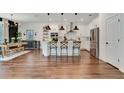 Bright, eat-in kitchen boasts stainless appliances, white cabinets, pendant lighting, and hardwood floors at 2335 Green Symphony Pl, Oviedo, FL 32765