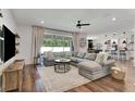 Cozy living room features a sectional couch, large windows, wood floors and modern decor at 2335 Green Symphony Pl, Oviedo, FL 32765