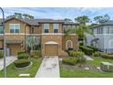 Inviting exterior showcasing a well-maintained townhome with a two-car garage and lush greenery at 2502 Seven Oaks Dr, St Cloud, FL 34772