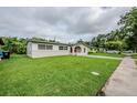 Single Gathering home with vibrant green lawn leading to the front entrance and long driveway at 26 Channing Ave, Orlando, FL 32811