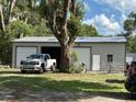 Large metal garage featuring ample parking and storage space in a wooded setting at 2847 Cr 756, Webster, FL 33597