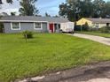This lovely single-story home has a gray exterior, a spacious lawn, and a cheerful red front door at 2847 W Harwood St # 0, Orlando, FL 32805