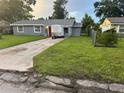 Well-kept single story home features a gray exterior, lush lawn, and a bright red front door at 2847 W Harwood St # 0, Orlando, FL 32805