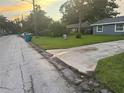 Street view of home for sale with gray exterior, green lawn, and mature trees at 2847 W Harwood St # 0, Orlando, FL 32805