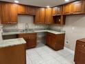 Kitchen area featuring wood cabinetry, laminate flooring, and granite countertops at 2847 W Harwood St # 0, Orlando, FL 32805