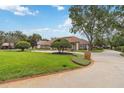 Expansive front lawn features manicured landscaping, a mature tree, and a circular driveway leading to the elegant home at 3215 Greens Ave, Orlando, FL 32804