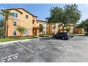 Inviting condo building with colorful facade, lush landscaping, and reserved parking spaces, creating an appealing curb appeal at 5467 Vineland Rd # 6110, Orlando, FL 32811