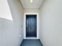 Close-up of a modern black front door set in a neutral-colored entrance, with a smart lock feature at 554 Pawnee Ct, Haines City, FL 33844