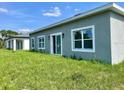 Exterior view of the home's backyard featuring a sliding door and lush green lawn at 611 Amazon Pl, Kissimmee, FL 34759