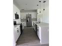 Modern kitchen with white cabinets, stainless steel appliances, and a large center island at 611 Amazon Pl, Kissimmee, FL 34759