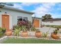 This house features a driveway, orange garage door and main door, and well-maintained landscaping at 840 Del Prado Dr, Kissimmee, FL 34758