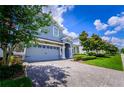 Beautiful two-story home featuring a stone-accented facade and brick driveway at 9014 Stinger Dr, Davenport, FL 33896