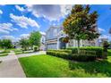 Well-maintained blue home with a two-car garage, lush green lawn and manicured bushes at 9014 Stinger Dr, Davenport, FL 33896