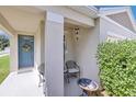 Inviting front porch featuring a cozy seating area, decorative wreath, and lush landscaping, creating a warm welcome at 115 Duchess Rd, Deland, FL 32724