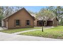 View of the side and front of a brown home with green lawn, walkway, and mature trees at 137 Hickory Ridge Cir, Lake Mary, FL 32746