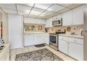 Well-lit kitchen featuring updated stainless steel appliances, white cabinets, and ample counter space at 14 Escondido Ct # 134, Altamonte Springs, FL 32701