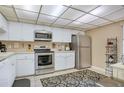 The kitchen has white cabinets, stainless steel appliances, and a black patterned rug at 14 Escondido Ct # 134, Altamonte Springs, FL 32701