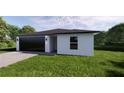 Stylish single-story home with a manicured lawn, complemented by a modern two-car garage at 17445 Sw 25Th Ct, Ocala, FL 34473