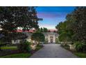 Elegant home featuring manicured greenery framing a symmetrical facade with a brick driveway at 1810 Oakbrook Dr, Longwood, FL 32779